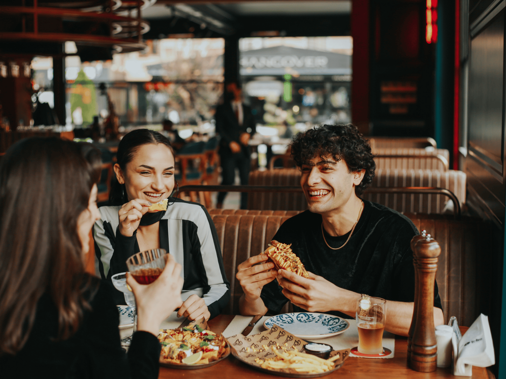 A group of friends dining at a restaurant with a buffett of food on the table 